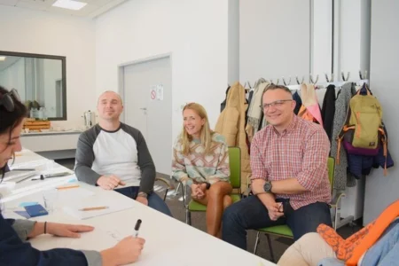 grupa osób wspólnie rozwiązujących problem podczas warsztatów